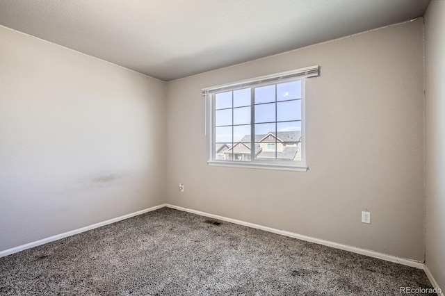 carpeted spare room featuring visible vents and baseboards