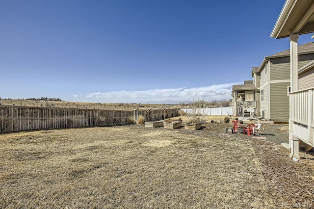 view of yard with a water view and a fenced backyard