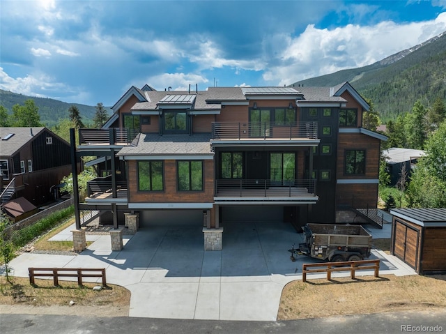 310 Creekside Aly Unit 4, Frisco, CO 80443 - rear view of house featuring a balcony, a mountain view, a garage, and concrete driveway
