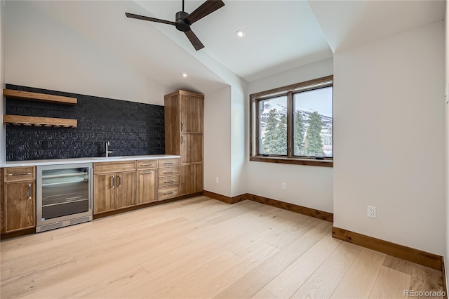 310 Creekside Aly Unit 4, Frisco, CO 80443 - kitchen featuring beverage cooler, ceiling fan, light countertops, light wood-type flooring, and vaulted ceiling