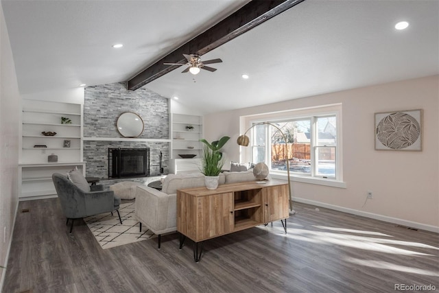 living room with ceiling fan, dark hardwood / wood-style floors, a stone fireplace, and lofted ceiling with beams