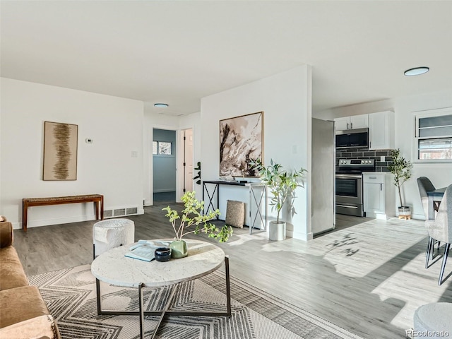 living room featuring a healthy amount of sunlight and light hardwood / wood-style flooring