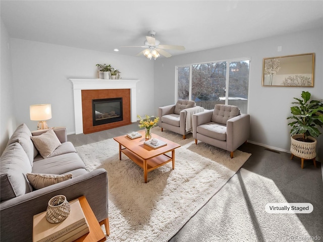 living room with a fireplace and ceiling fan