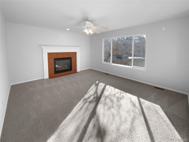 unfurnished living room featuring ceiling fan and dark carpet