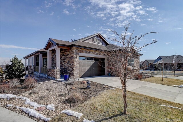 view of front facade featuring a porch, stone siding, driveway, and an attached garage