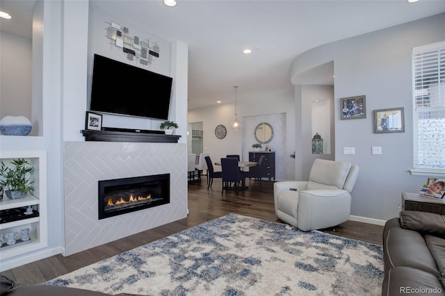 living room featuring dark wood-style floors, recessed lighting, a fireplace, and baseboards