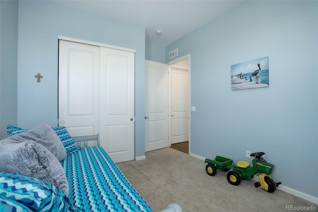 bedroom with baseboards, visible vents, carpet floors, and a closet