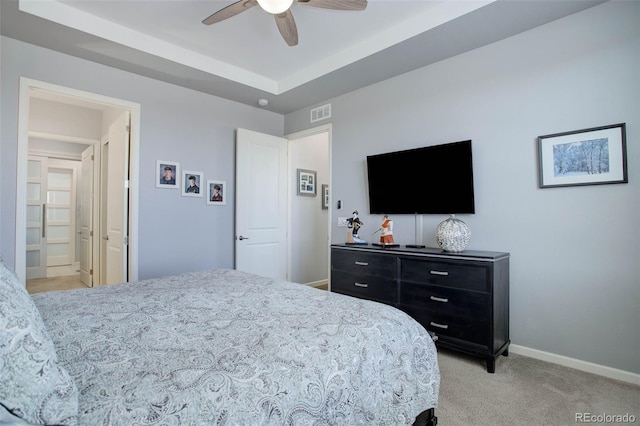 bedroom with visible vents, a raised ceiling, a ceiling fan, carpet floors, and baseboards