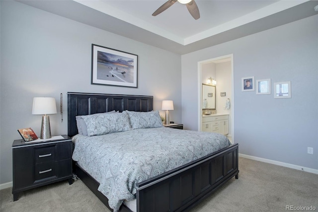 bedroom with light carpet, ensuite bath, baseboards, and a ceiling fan