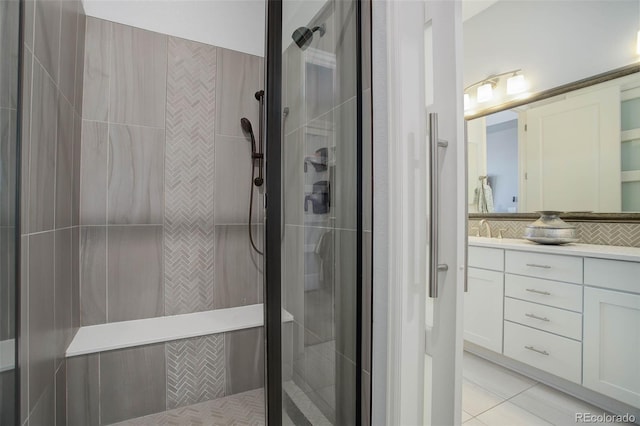 full bathroom featuring tile patterned floors, a shower stall, vanity, and tasteful backsplash