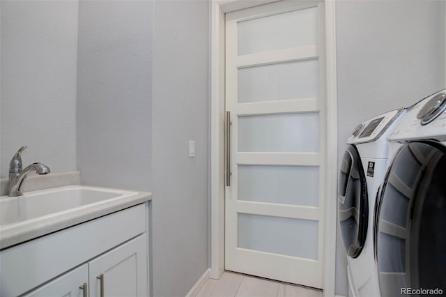 laundry room with a sink, cabinet space, and washing machine and dryer