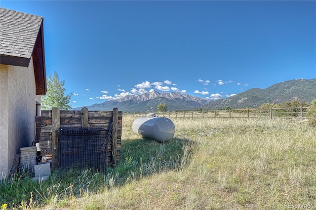 view of yard featuring a mountain view and fence