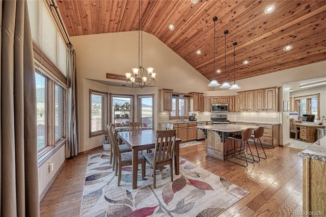 dining space with sink, wooden ceiling, an inviting chandelier, high vaulted ceiling, and light hardwood / wood-style floors