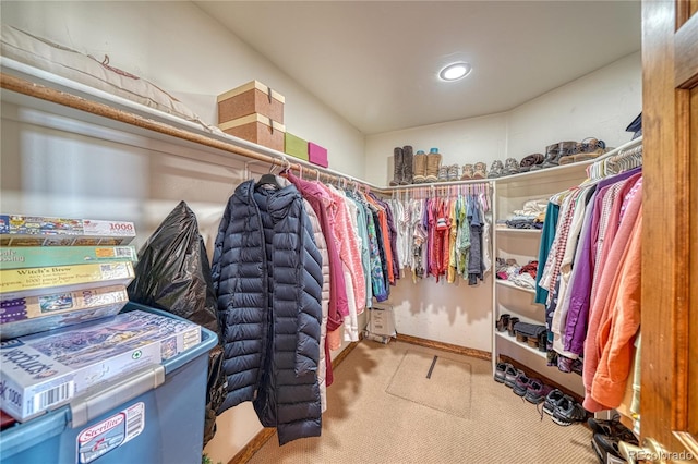 spacious closet featuring light colored carpet