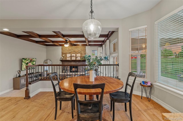 27290 E Nova Cir, Aurora, CO 80016 - dining space featuring light wood-style floors, coffered ceiling, beam ceiling, a fireplace, and ceiling fan
