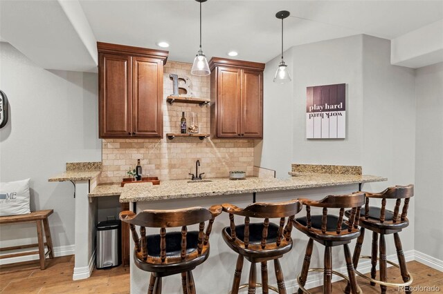 27290 E Nova Cir, Aurora, CO 80016 - indoor wet bar with backsplash, hanging light fixtures, light wood-style floors, and recessed lighting