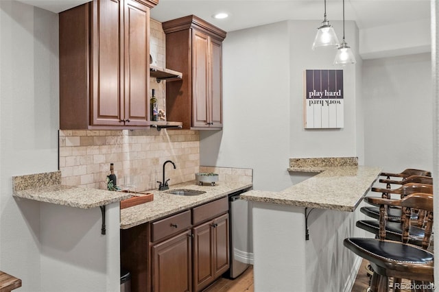 27290 E Nova Cir, Aurora, CO 80016 - kitchen with a breakfast bar, a peninsula, decorative backsplash, stainless steel dishwasher, and recessed lighting
