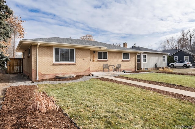 rear view of house featuring a lawn and a patio