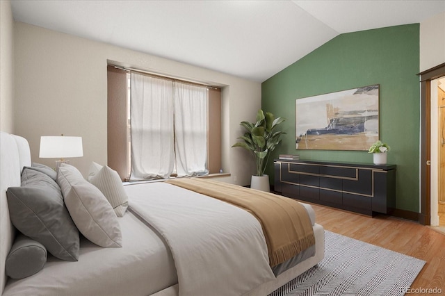 bedroom with lofted ceiling and wood finished floors