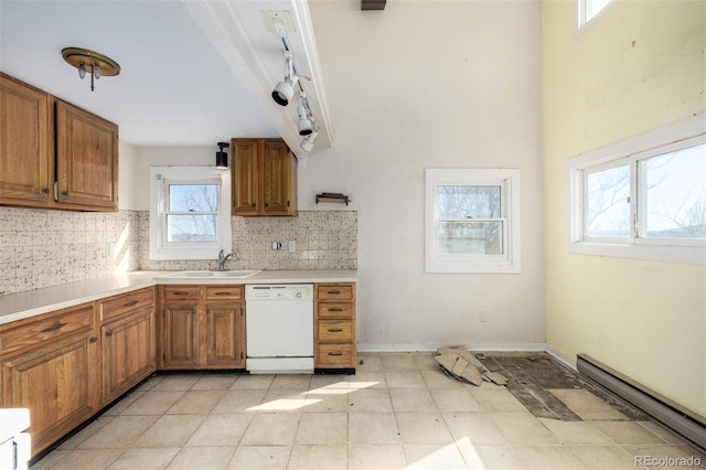 kitchen featuring a baseboard heating unit, brown cabinetry, white dishwasher, and a sink