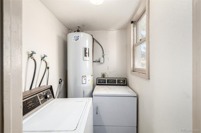 clothes washing area with laundry area, electric water heater, and washer and dryer