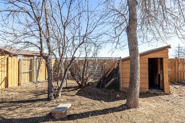 view of yard featuring a storage shed, an outdoor structure, and fence