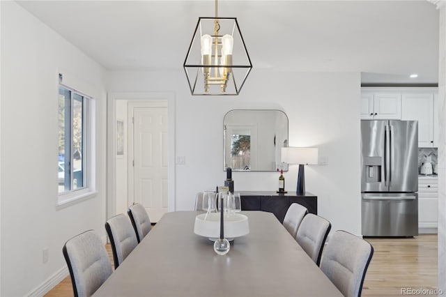 dining space with a chandelier and light wood-type flooring