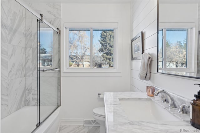 full bathroom featuring enclosed tub / shower combo, vanity, and toilet