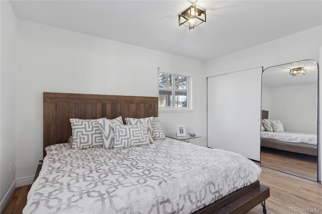 bedroom with wood-type flooring and a closet