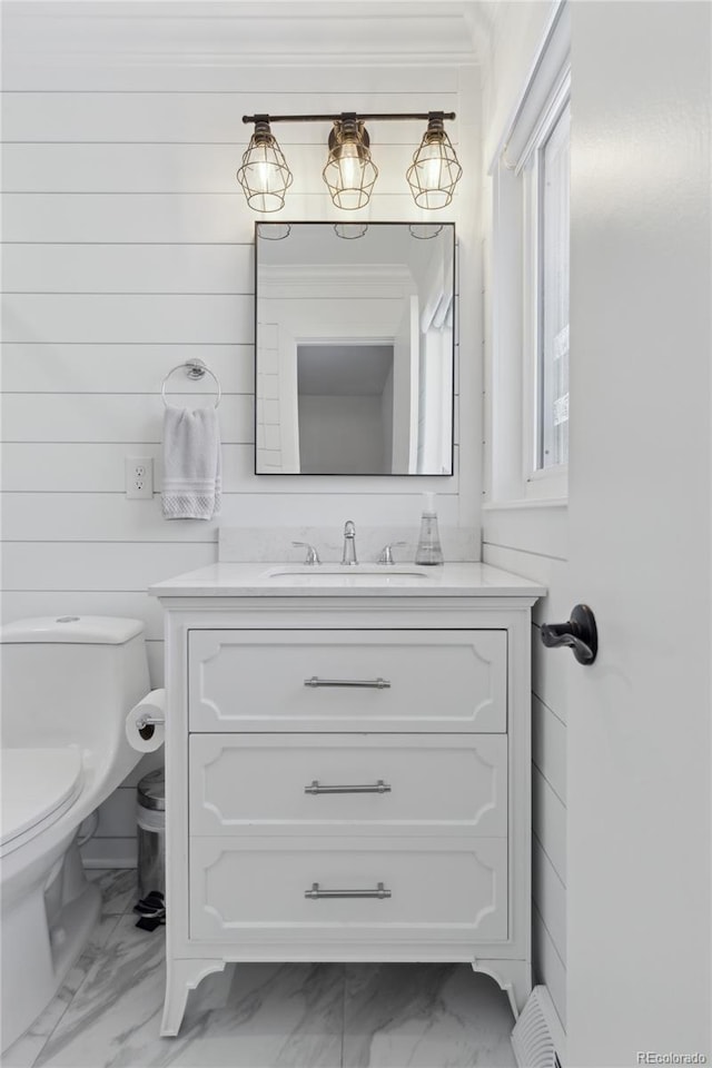 bathroom featuring ornamental molding, vanity, and toilet