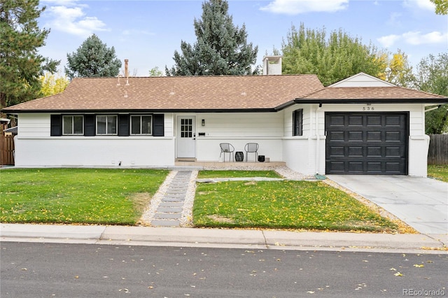 ranch-style house featuring a garage and a front lawn