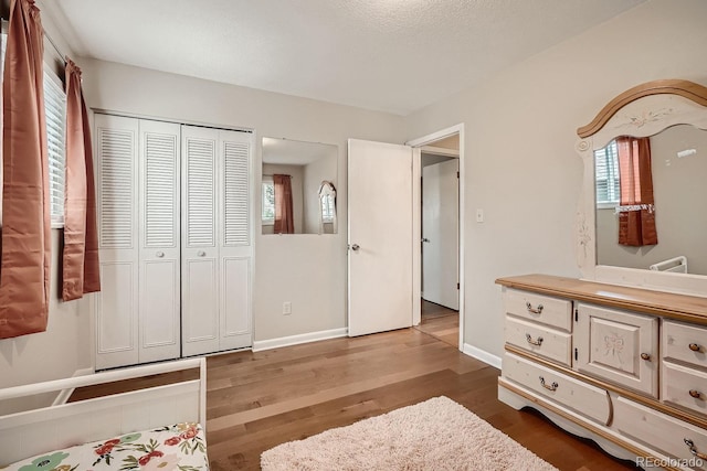 bedroom with multiple windows, light hardwood / wood-style floors, and a closet