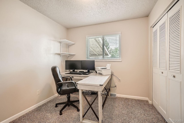 carpeted office featuring a textured ceiling