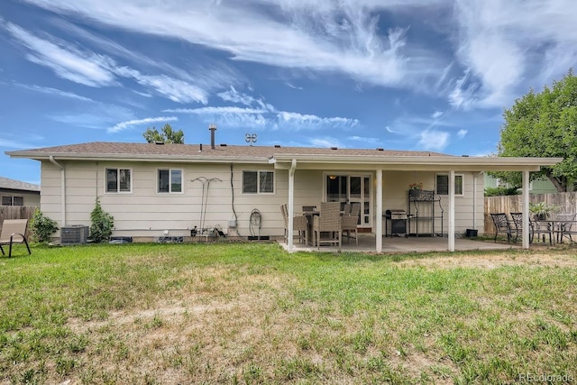 rear view of property with a yard, a patio, and central air condition unit