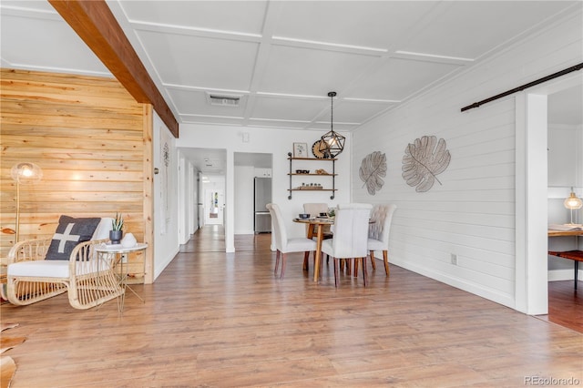 505 S Roosevelt Rd, Lafayette, CO 80026 - dining room featuring wood walls, light wood-style flooring, a barn door, and baseboards