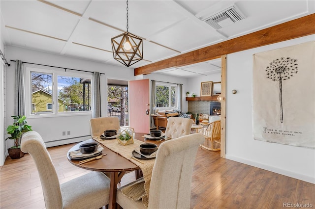 505 S Roosevelt Rd, Lafayette, CO 80026 - dining area featuring baseboard heating, wood-type flooring, baseboards, beam ceiling, and a fireplace