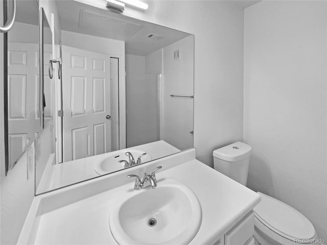 bathroom featuring toilet, walk in shower, and vanity