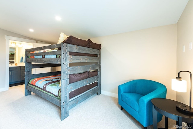 carpeted bedroom featuring lofted ceiling and connected bathroom