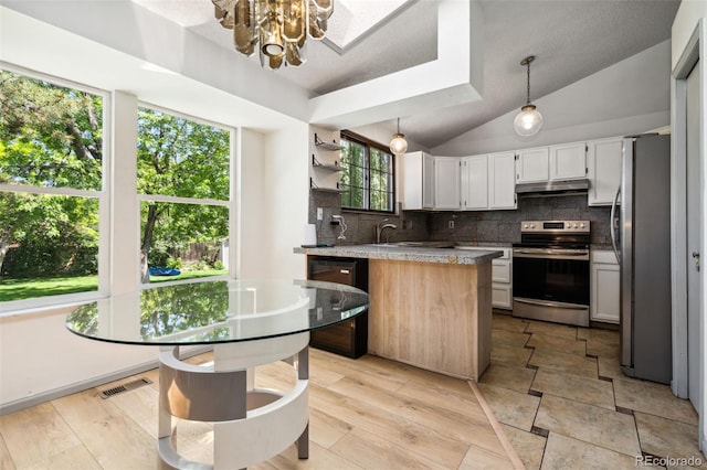 6544 Alkire Ct, Arvada, CO 80004 - kitchen featuring stainless steel appliances, under cabinet range hood, tasteful backsplash, a chandelier, and vaulted ceiling