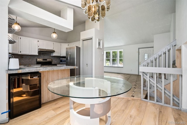 6544 Alkire Ct, Arvada, CO 80004 - kitchen featuring stainless steel appliances, under cabinet range hood, decorative backsplash, high vaulted ceiling, and pendant lighting