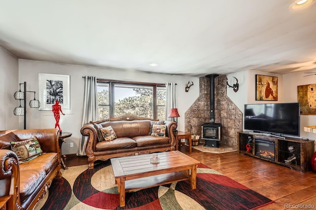 living room with a wood stove and hardwood / wood-style flooring