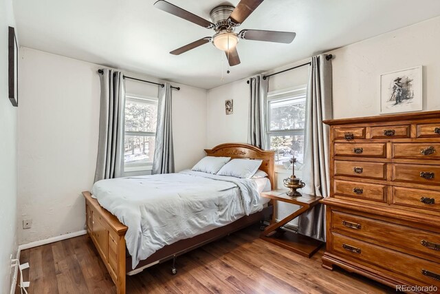 bedroom with a ceiling fan, baseboards, and wood finished floors