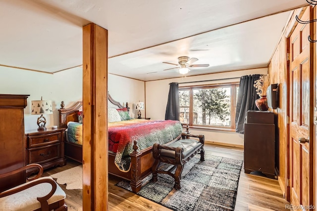 bedroom featuring ceiling fan, ornamental molding, and wood finished floors