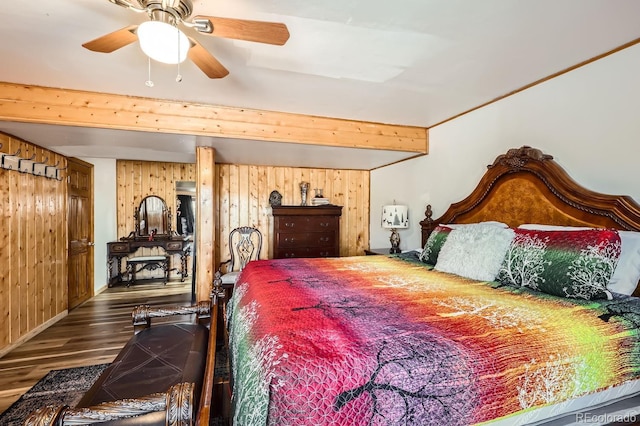 bedroom with ceiling fan, wood finished floors, beam ceiling, and wooden walls