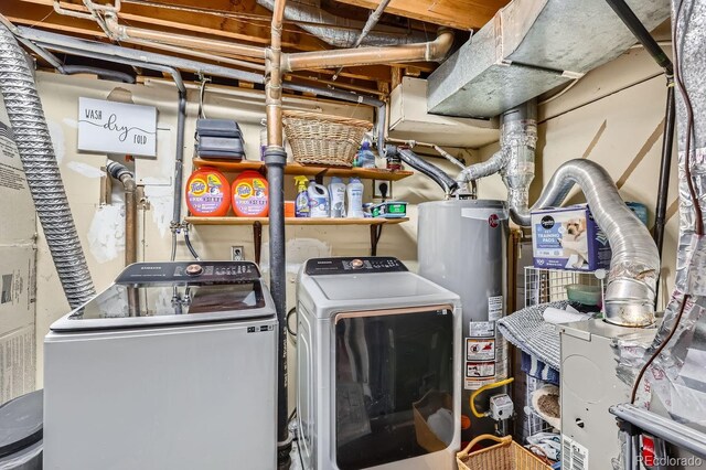 clothes washing area with laundry area, water heater, and washing machine and clothes dryer