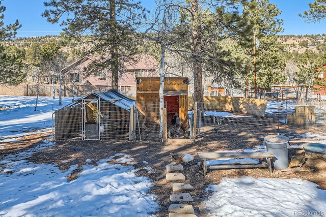 yard covered in snow with exterior structure and an outdoor structure