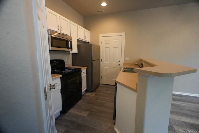 kitchen with white cabinetry, sink, dark hardwood / wood-style flooring, kitchen peninsula, and stainless steel appliances