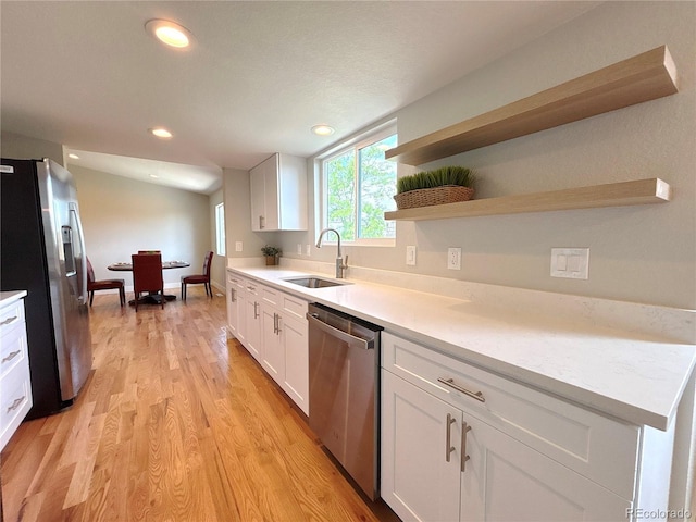 18073 E Belleview Pl, Centennial, CO 80015 - kitchen featuring stainless steel appliances, a sink, light wood finished floors, white cabinetry, and light countertops