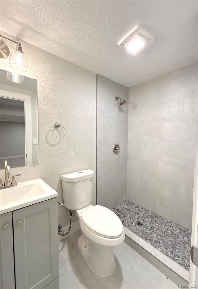 18073 E Belleview Pl, Centennial, CO 80015 - full bathroom with tiled shower, toilet, vanity, a textured wall, and a textured ceiling