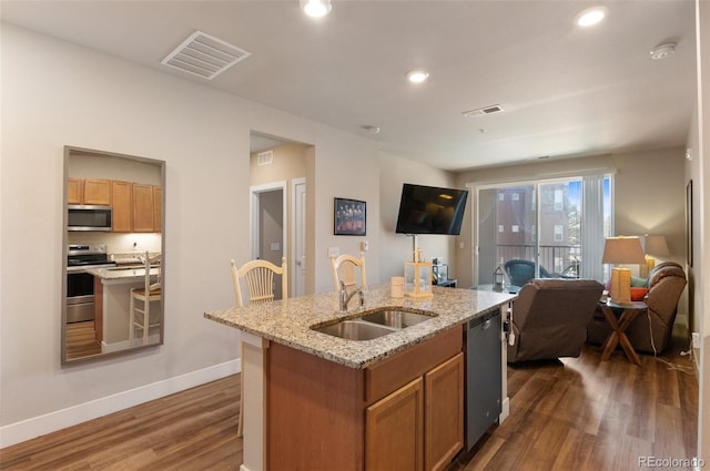 kitchen featuring visible vents, a sink, a kitchen island with sink, appliances with stainless steel finishes, and open floor plan